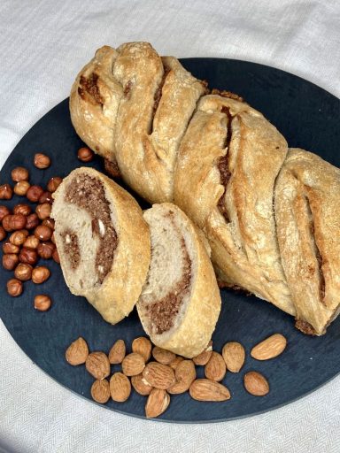 Saftiger Dinkel-Nusszopf mit einer intensiv schmeckenden Fülle aus Mandeln, Haselnüssen und viel Zimt. Gelockert mit reinem Sauerteig.